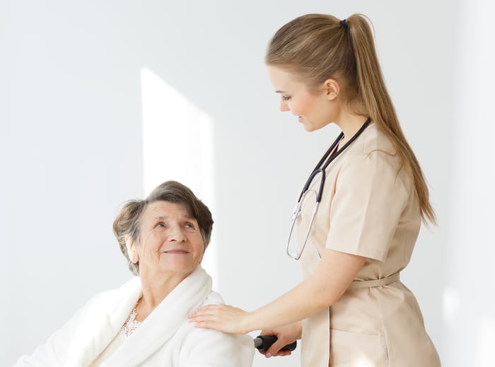 woman-on-wheelchair-and-caregiver-P9DJ9TV